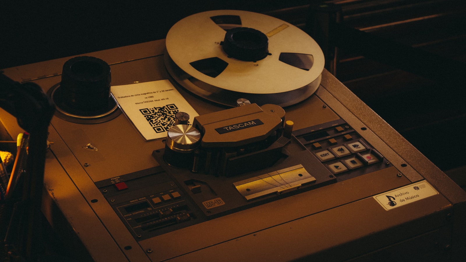 A Tascam MS-16 reel to reel tape machine on display with a spool of tape loaded and an EDIT button on the transport panel, from the era when cutting a section out of a track was a physical job